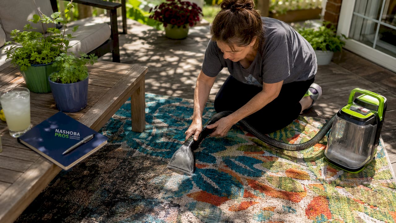 Woman cleaning carpet at home